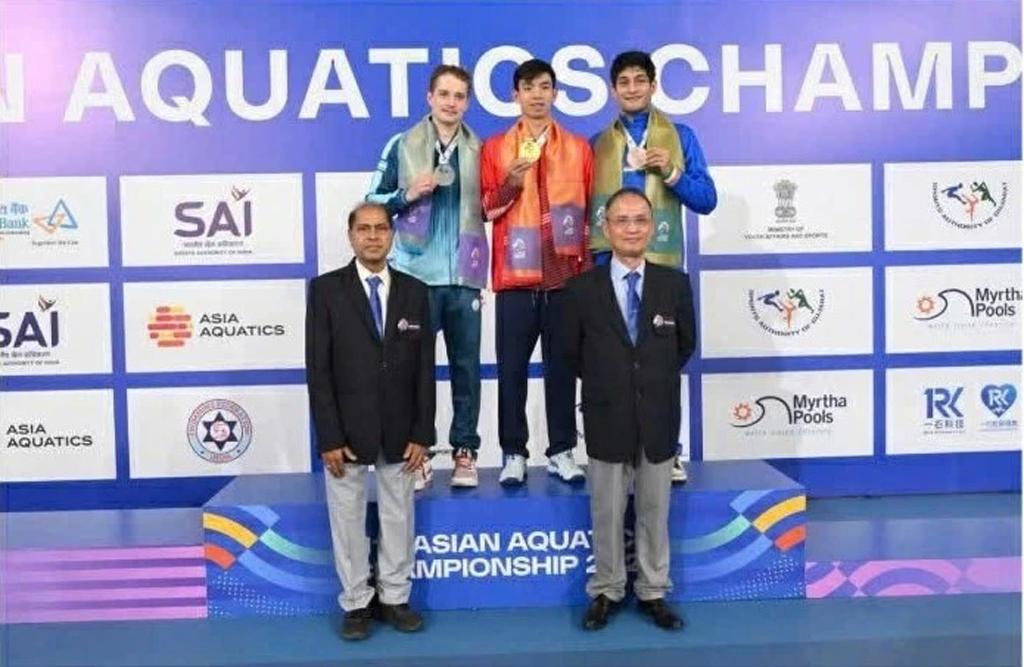 Huy Hoang stands at the centre of the podium with his Asian gold medal.
