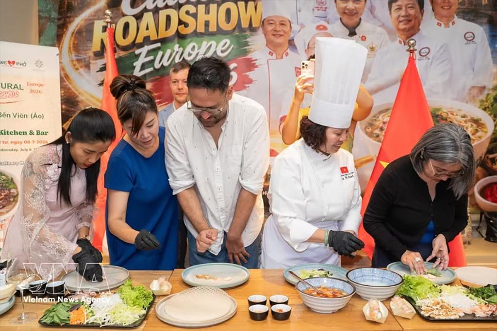 Visitors participate in a live demonstration of pho roll preparation at the event. (Photo: VNA)