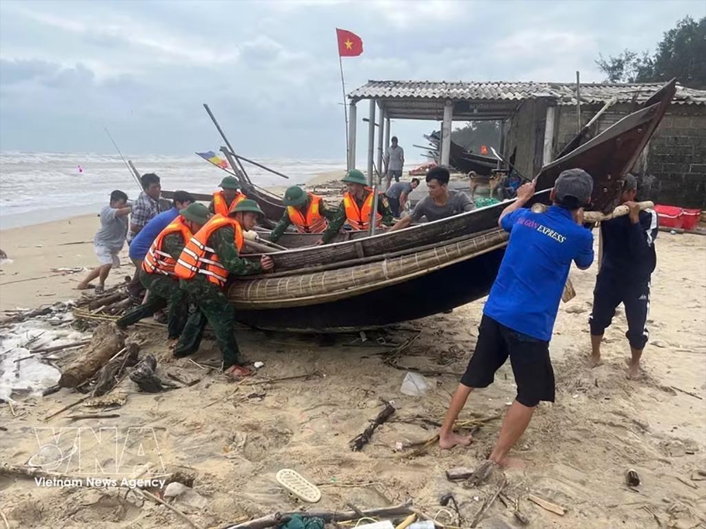Pulling a boat ashore to shelter from the storm (Photo: VNA)