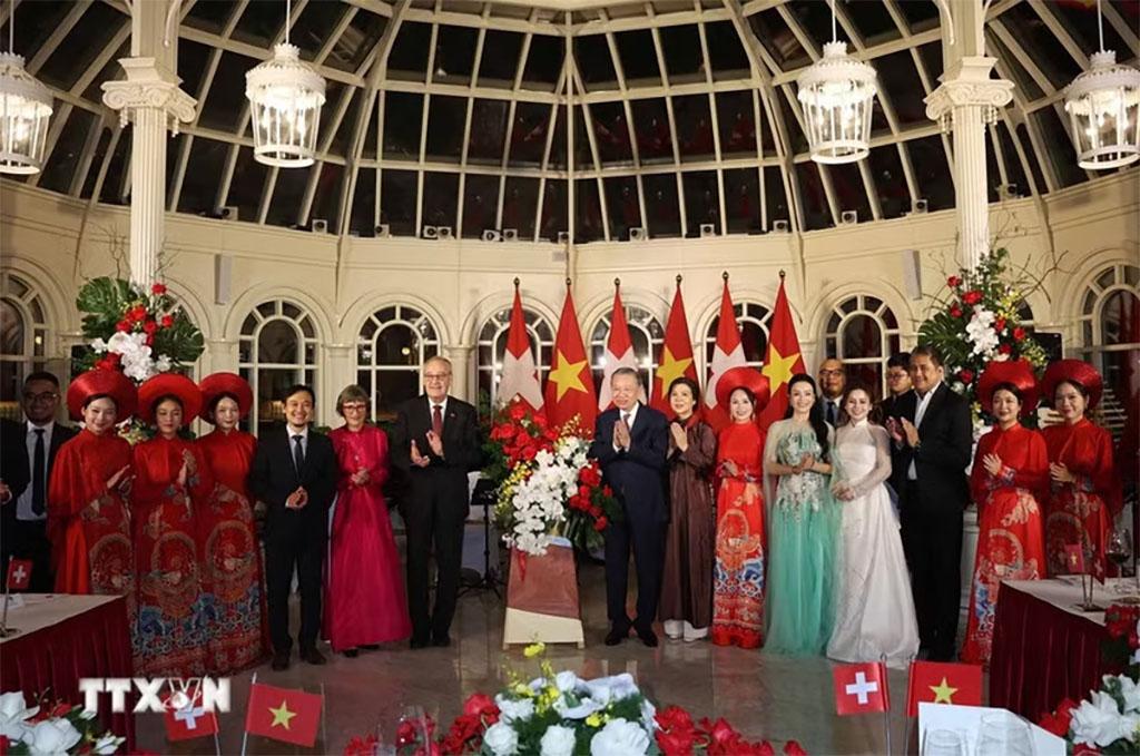 General Secretary of the Communist Party of Viet Nam Central Committee and President To Lam (8th from left, first row) and his spouse Ngo Phuong Ly, and Swiss President Guy Parmelin and his spouse Caroline Parmelin present flowers to artists performing at the banquet. (Photo: VNA)