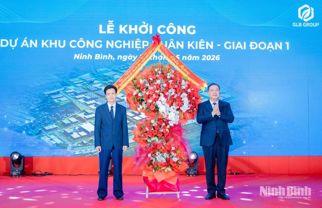 Standing Deputy Prime Minister Pham Gia Tuc presents flowers to congratulate investor.