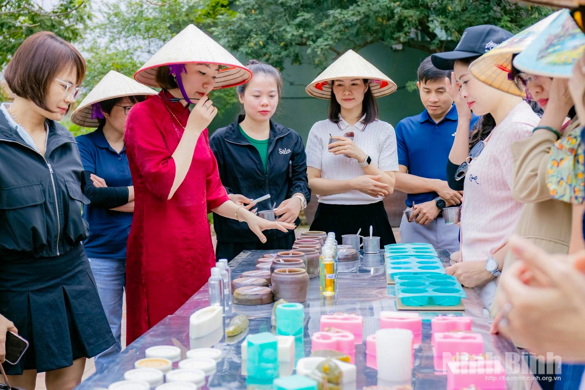 Tourists learns how to make soap at Sinh Duoc herbal cooperatives in Gia Vien commune.