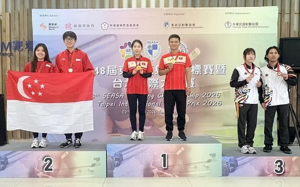 Gold medallists Le Thi Mong Tuyen and Nguyen Thanh Nam celebrate on the podium. (Photo: qdnd.vn)