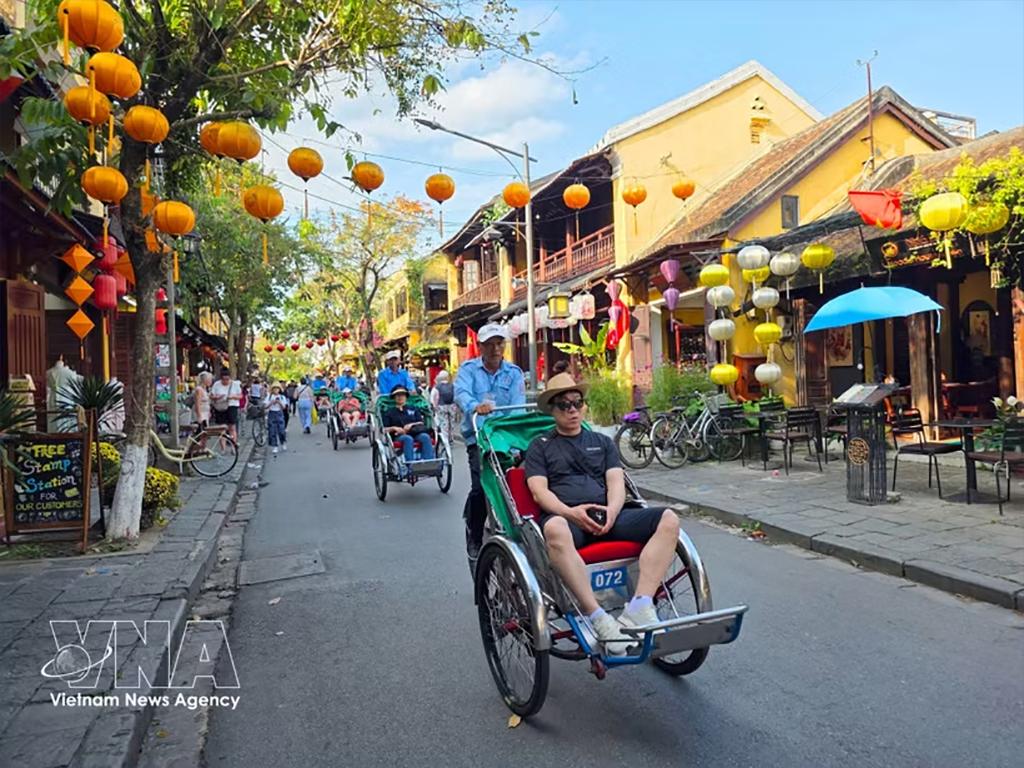 Tourists relax on eco-friendly cyclo rickshaws while exploring Hoi An's ancient town. (Photo: VNA)